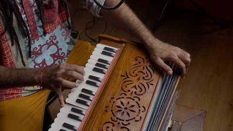 Traditional world. Folk instrument. Indian man playing harmonium in the sound studio. Hindi male person plays meditation music.