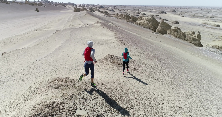 Two trail runners cross country running in the desert