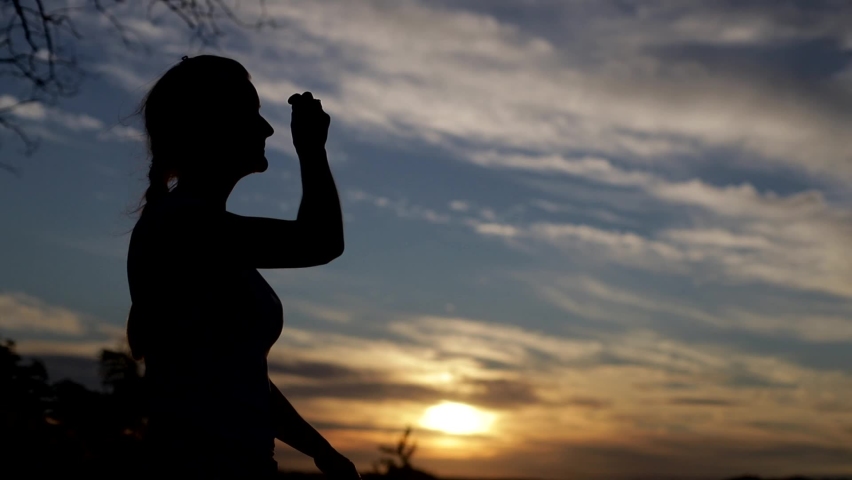 Silhouette of woman praying with Amazing dramatic sky sunset background Royalty-Free Stock Footage #1058864410