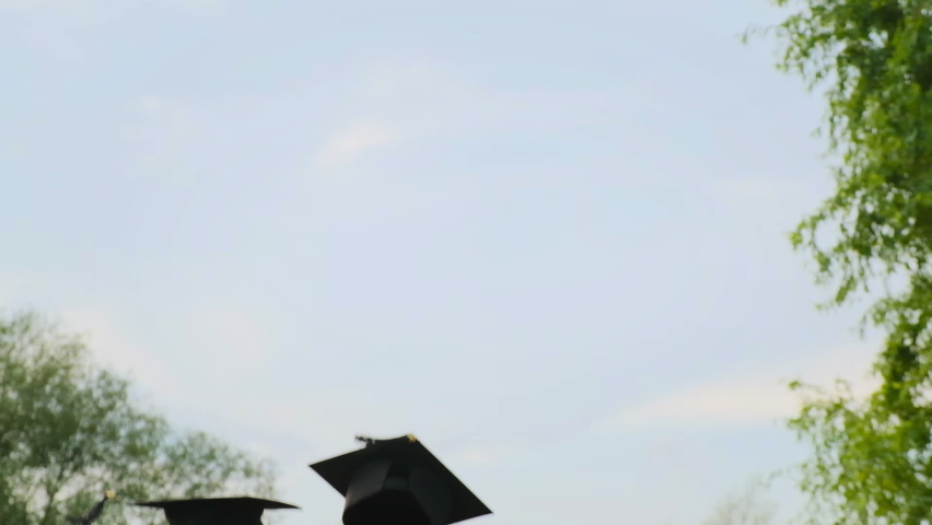 Close up in slow motion of university high school graduates throwing their square academic tudor bonnet cap into the air graduation ceremony. Students Celebration of a MBA bachelor and master degree Royalty-Free Stock Footage #1058873227