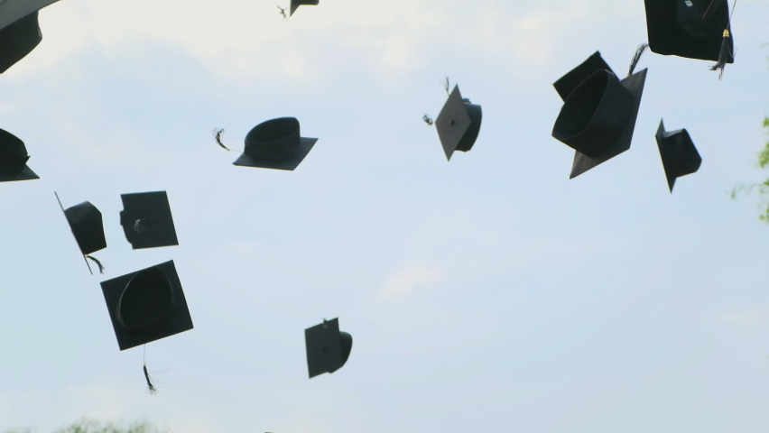 Close up in slow motion of university high school graduates throwing their square academic tudor bonnet cap into the air graduation ceremony. Students Celebration of a MBA bachelor and master degree | Shutterstock HD Video #1058873227