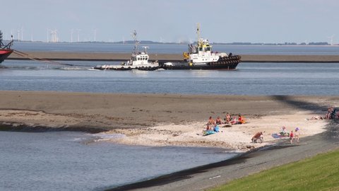 Eemshaven, Netherlands-Circa august 2020:tugboats and transport barge