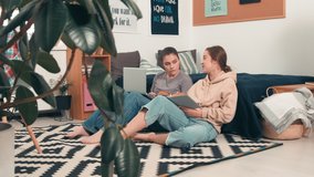 Tracking shot of young female college students sitting together on floor by bed in their cozy dorm and doing assignment - Powered by Shutterstock - Get 15% off with code: PIKWIZARD15