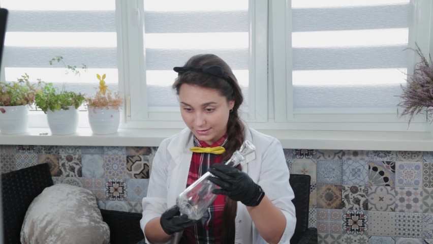 Young woman conducting chemical experiments at home.
