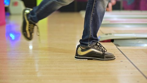 The bowling player's feet slide abruptly and stop abruptly before the start of the track. The game threw a bowling ball