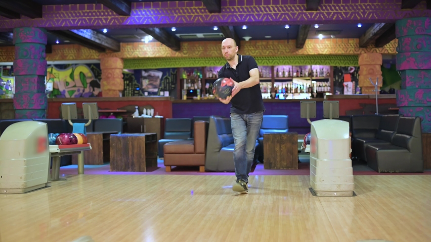 Bald man throws a ball while bowling | Shutterstock HD Video #1058885140