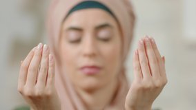 Young muslim woman raises her hand and prays.Close-up praying muslim woman.Slow motion video.