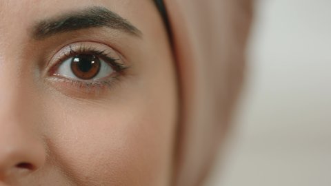 Attractive Muslim girl wearing traditional hijab scarf. Woman looking at camera with black eyes.