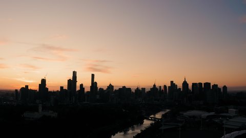 Aerial sunset view Melbourne city CBD skyline silhouette along Yarra River Victoria Australia