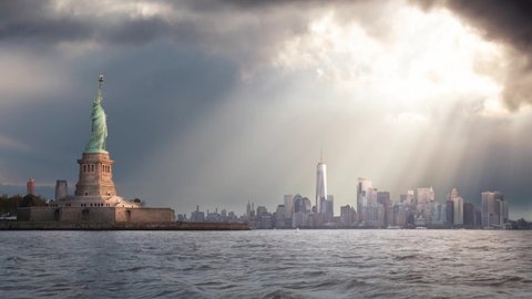 Cinemagraph Continuous Loop Animation. Panoramic view of the Statue of Liberty and Downtown Manhattan in the background during a vibrant cloudy sunrise. Taken in New York City, NY, United States.