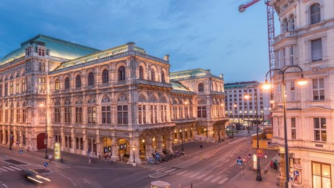 Beautiful view of Wiener Staatsoper (Vienna State Opera) aerial day to night transition timelapse in Vienna, Austria. Illuminated historic buildings and traffic on streets