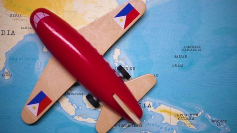 A red plane with a flag of Philippines attached to its wings is crossing the map of Philippines.