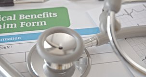 Medical benefits claim form on a table in a doctor or physician office. Medical benefits claim is a part of health insurance agreement  contract that covers risk of a person incurring medical expense