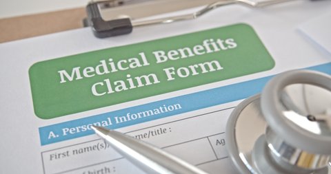 Medical benefits claim form on a table in a doctor or physician office. Medical benefits claim is a part of health insurance agreement  contract that covers risk of a person incurring medical expense