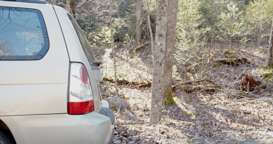 A man grabs his fishing gear from his car