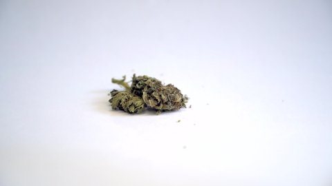 Cannabis buds are on the table. Defocus.
Marijuana bud close up isolated texture. Cannabis on white paper. BMPCC. Marijuana, weed, drug smoking concept. CBD, THC.
Preparing cannabis for consumption
