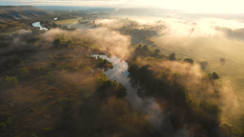 Aerial drone view of sunrise over misty river. Calmness, relaxation, meditation, solitude, beauty of nature concept | Shutterstock HD Video #1058913401