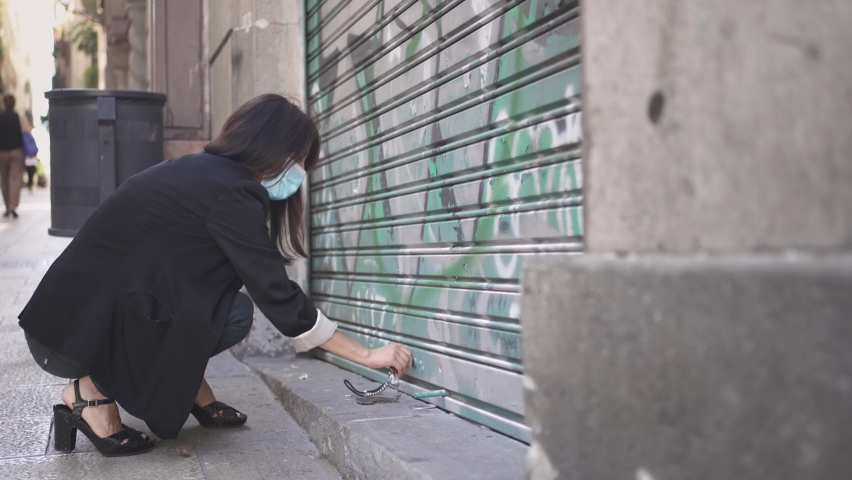 Businesswoman wearing face mask closing business activity-due to Coronavirus Crisis. Woman closing shop after Covid Economy recession. Coronavirus Economic Crisis. Royalty-Free Stock Footage #1058917055