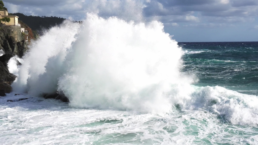 Devastating and spectacular sea storm in Framura, Liguria Cinque Terre - sea waves crash on the rocks of the coast creating an explosion of water - melting glaciers increase the volume of sea water | Shutterstock HD Video #1058920778