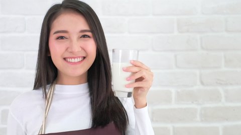 Attractive Asian woman drinking milk and smiling at home close up face.healthy life style.