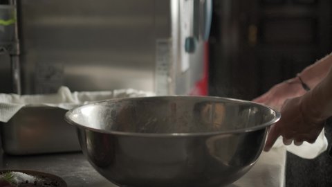 The cook covers the bowl with the dough with a towel to activate the yeast. 4k. Slow motion