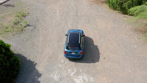 REP.DOM , BANI / Dominican Republic - 09 03 2020: Aerial view of a blue colored mini Cooper road chase on a tropical island