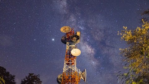Repeater electric tower on the milky way Time-lapse Beautiful  sky background, transmission power, and a Parts of electrical equipment and high voltage power line insulators at night