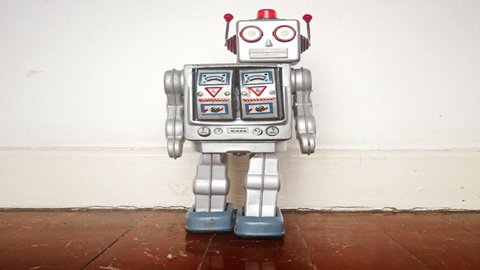 retro silver robot moving head and dancing on a old wooden floor stop motion	