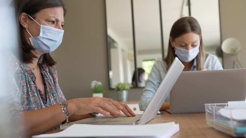 Business women working in office with face mask | Shutterstock HD Video #1058943884