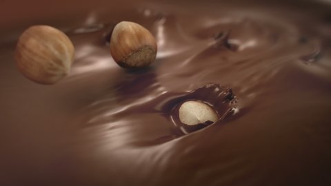 Hazelnuts Splashing Into Liquid Milk Chocolate in 4K Super slow motion