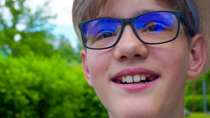 street portrait of a modern positive teenager boy with glasses.extreme close-up