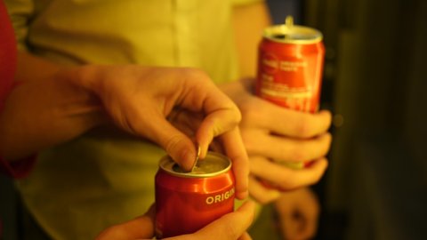 WROCLAW, POLAND - SEPTEMBER 10, 2020: Close-up of two People Opening a Metal Can of Soda Coca Cola