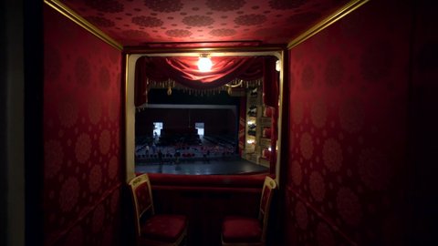 Milan, Italy, 09.09.2020: Teatro alla Scala. A view inside the building of an empty concert hall made of red velvet and an empty stage. Opera theatre. The workers set up a stage for the performances.