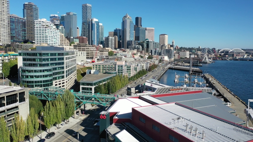 Aerial / drone footage of the Seattle waterfront, Belltown, Elliott Bay, marina and Cruise Ship Terminal without people downtown, in the commercial district of Seattle, Washington during the pandemic