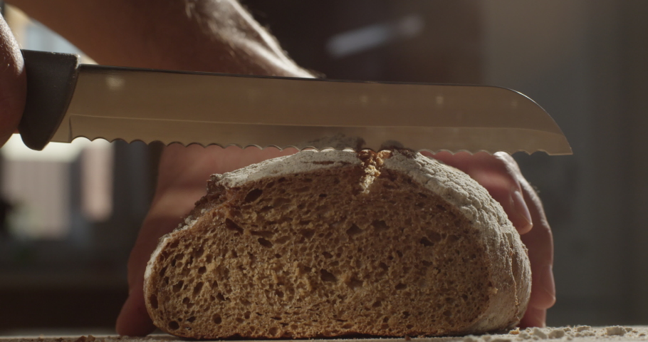 Cutting with a Knife Crusty Artisan Bread in the Kitchen on a Sunny Day Shot on Red Camera Royalty-Free Stock Footage #1058963486