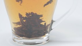 Close up view of cup with brewed tea on white