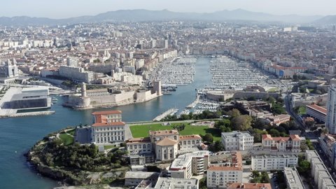 Marseille port city aerial view in southern France. Beautiful sunny day looking from above feat. The Old Port (Vieux Port) of Marseille surrounds a lively yacht marina 4K