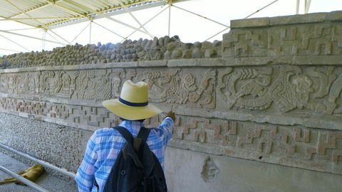 close up to a tour guide explaining the incredible well preserved hieroglyphs in the beautiful archaeological site of Tula
