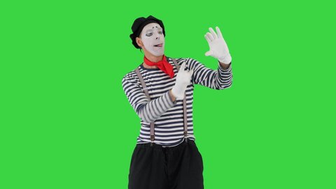 Funny mime in white gloves making selfie photos on a Green Screen, Chroma Key.