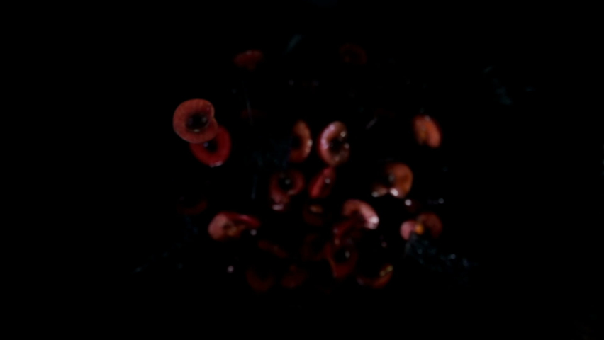 Halves of delicious cherries are bouncing up and rotating with splashes of juice on a black background in slow motion Royalty-Free Stock Footage #1058982503
