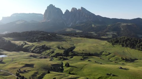 Drone flying forward unveiling majestic Seiser Alm meadows in Dolomites Italy. Sunrise at Alpe di Suisi mountain valley in Alps of South Tyrol	

