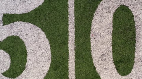 Rotating reveal of 50 yard line marker on football field 4k