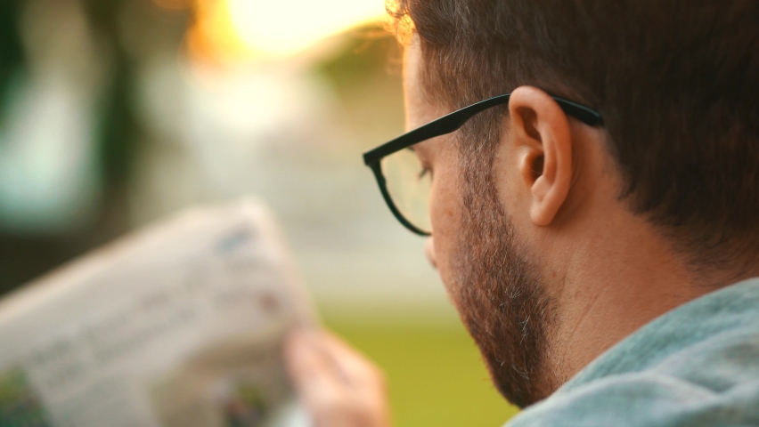 Cinematic Man Reading Newspaper Outside At Home In His Garden. Royalty-Free Stock Footage #1058989538