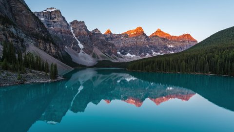 Zoom out timelapse view of sunrise over Moraine Lake and Valley of the Ten Peaks, Banff National Park, Alberta, Canada. 