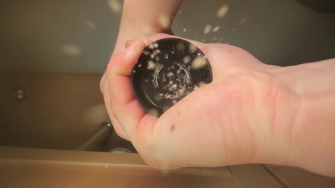 Pepper mill grinding fresh black pepper on food, viewed from below, slow motion particles from 120 fps footage