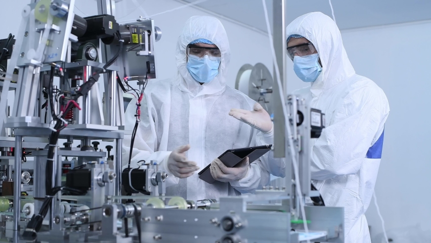 Worker science Technologist in white protective uniform with hairnet and mask operating on mask manufacture industrial to control produce and protective for virus,new normal concept. Royalty-Free Stock Footage #1058993327