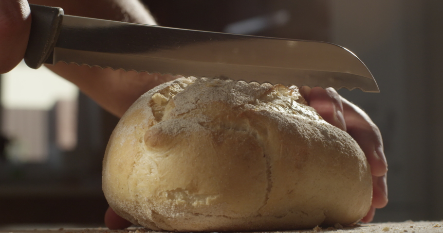 
Man Cutting a Piece of Bread with a Knife in the Kitchen on a Sunny Day Shot on Red Camera | Shutterstock HD Video #1058996315