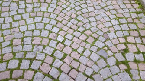 Moving on stone paving road in old city. Walkway with cobblestones, rectangular and quarried stone. Roman road.