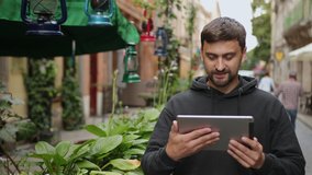 Urban man using tablet computer outside app on 5g wireless device. Casual young professional male in late 20s. Hand touching digital screen pad pc - Powered by Shutterstock - Get 15% off with code: PIKWIZARD15