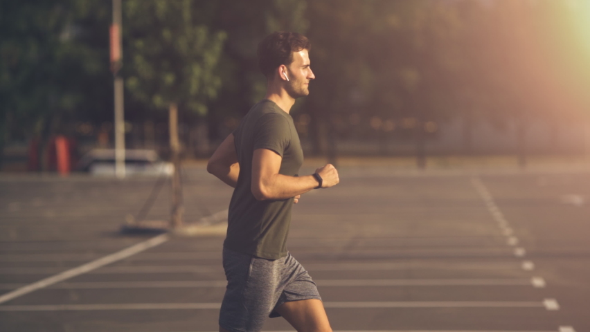 The smiling young man jogging in the morning. slow motion Royalty-Free Stock Footage #1059011156